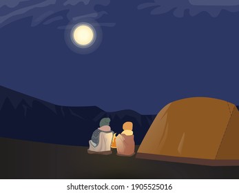 Overnight outdoor camping near the mountains. Campers sitting by a bonfire watching bright full moon next to a tent. Used to portray outdoor activities, families and friends spending time together.