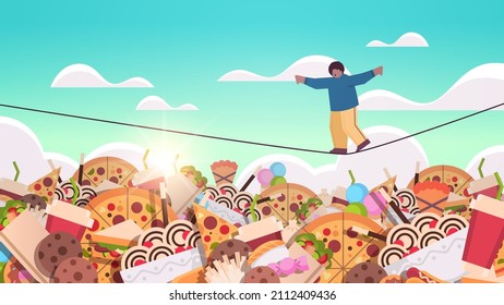 overweight boy balancing on rope above junk food assortment of fast food unhealthy nutrition junkfood addiction