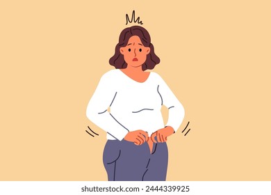 Overweight woman cannot fit into old jeans due to excess weight caused by overeating and sedentary lifestyle. Problem of excess weight surprises girl who needs to follow diet or exercise