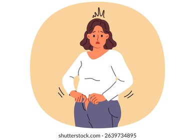 Overweight woman cannot fit into old jeans due to excess weight caused by overeating and sedentary lifestyle. Problem of excess weight surprises girl who needs to follow diet or exercise
