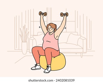 Overweight woman doing sports, wanting to lose weight, lifts dumbbells sitting on inflatable fitness ball. Girl is trying to get rid of excess weight with help of fit training and physical exercises.