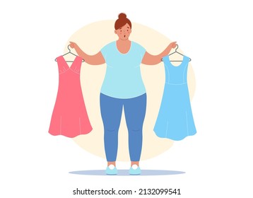 Overweight woman gets upset because of the extra pounds. She is holding her old dresses in her hands, which no longer fit, they are too small for her.