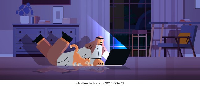 overworked arab businessman freelancer looking at laptop screen arabic man with dog lying on floor in dark night room