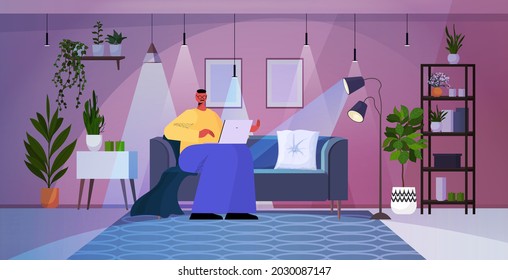 overworked businessman using laptop in dark night living room social media network concept