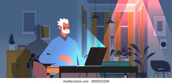 overworked senior man freelancer looking at laptop screen aged man sitting at workplace in dark night home room