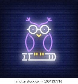 Owl on book neon sign. Clever owl in glasses sitting on book. Night bright advertisement. Vector illustration in neon style for education and literacy