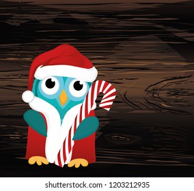 Owlet  in Santa Claus costume holds a Christmas candy.  Greeting card for the new year. Empty place for your text or advertisement. Vector on wooden background.