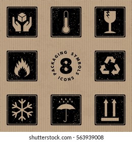 Packaging Symbols Handle with Care Storage Temperature Fragile Flammable Recycle Freezable Keep Dry This Way Up Icons Set - Black Grunge Inverted Elements on Cardboard Background - Stamp Stencil Style