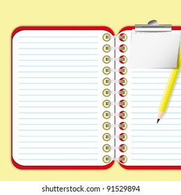 Pad and paper clip on red notebook.