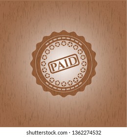 paid icon inside wooden emblem