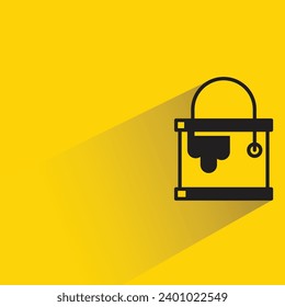 icono de cubo de pintura con sombra sobre fondo amarillo
