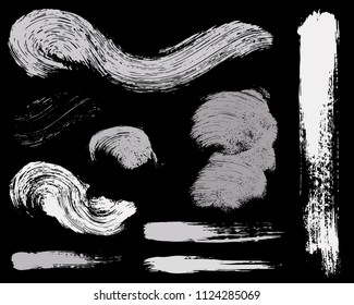 Paint lines grunge collection. Set of silver grungy hand drawn brush strokes isolated on black. Abstract ink texture, design elements, borders or frames. Brush strokes set backgrounds.
