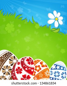 Painted Easter eggs and flower on a green meadow