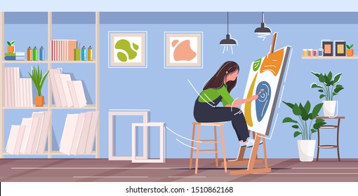 painter using paintbrush and palette woman artist sitting in front of easel art creativity hobby creative occupation concept modern workshop studio interior full length horizontal