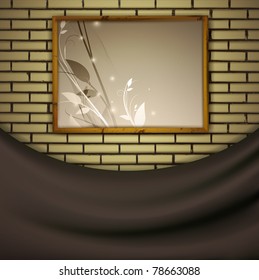 painting in a wooden frame at brick wall over curtain drapery