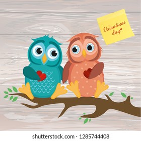 A pair of cute owlet sitting on a branch. Yellow sheet of paper for notes. Sticker. Owls in love hold hearts for each other. Greeting card for Valentine's Day. Vector illustration on wooden background