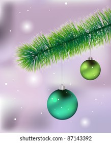 Pair of green Christmas baubles hanging from the pine tree branch