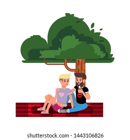 A pair of guys embracing under a tree sitting on the rug. Rest on nature.  Emotional scene of love and devotion.