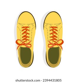 A pair of sport style yellow shoes with shoelaces top view.