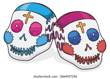 Pair of sugar skulls as offering for Day of the Dead celebration, with traditional Mexican patterns and crosses.