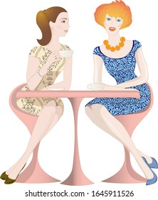 Pair of women in beautiful dresses sitting at the table and chatting