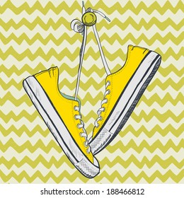 Pair of yellow sneakers on chevron background drawn in a sketch style. Sneakers hanging on a peg.