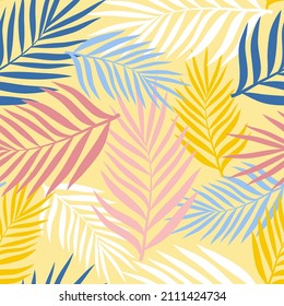 Palm leaves of different colors on a pale yellow background. Seamless pattern for any use.