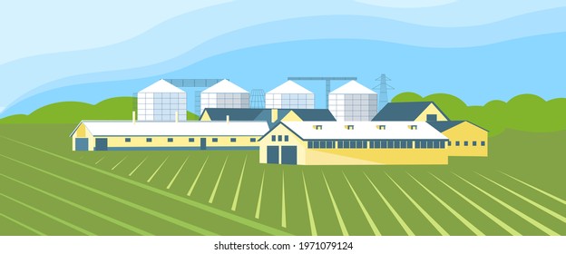 Panorama of an agricultural complex with a grain storage and agricultural hangars on the background of fields