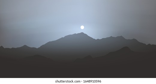 Panoramic view of the Alps on a foggy day, with the sun rising over the mountain range, just above Mont Blanc.