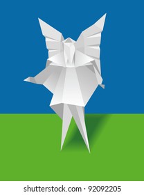 A paper angel on a green background. Origami