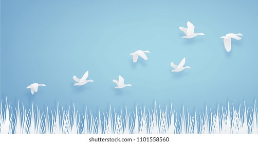 paper art of duck or teal birds flying over the grass in the sky on blue background. paper cut concept.
