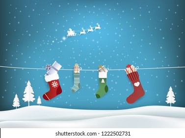 Paper art illustration of Santa and stockings and gift box hanging on a clothesline. Christmas holiday season background