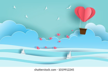 Paper art style of origami heart shaped hot air balloon flying in the air over beautiful beach with many hearts floating, flat-style vector illustration.