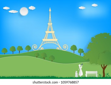 Paper art vector illustration of Eiffel tower, white poodle dog, white girl, green mountains, green trees, green grass on blue sky background.