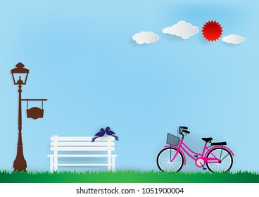 Paper art vector illustration of pink bicycle, white chair, blue birds, brown lantern, white clouds and red sun and green grass on sky background.