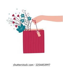 A paper bag with flowers, leaves and branches in the girl's hand.