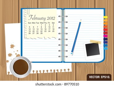 Paper and blue Notebook With a cup of coffee and photo frame. on brown wood background. Calendar 2012 February Vector template for design work