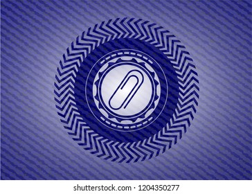 paper clip icon inside badge with denim background