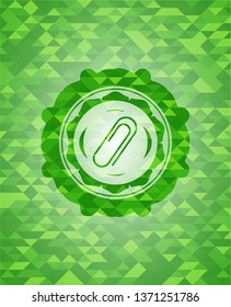 paper clip icon inside green emblem. Mosaic background