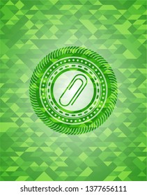 paper clip icon inside green emblem. Mosaic background