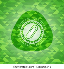paper clip icon inside green emblem. Mosaic background