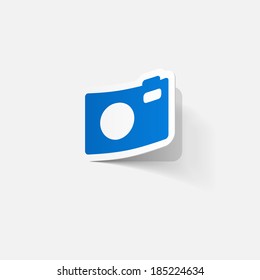 Paper clipped sticker: Digital compact photo camera. Isolated illustration icon