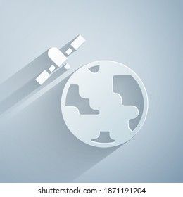 Paper cut Artificial satellites orbiting the planet Earth in outer space icon isolated on grey background. Communication, navigation concept. Paper art style. Vector