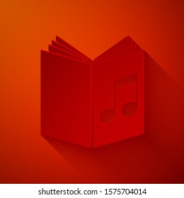 Paper cut Audio book icon isolated on red background. Musical note with book. Audio guide sign. Online learning concept. Paper art style. Vector Illustration