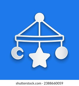 Paper cut Baby crib hanging toys icon isolated on blue background. Baby bed carousel. Paper art style. Vector