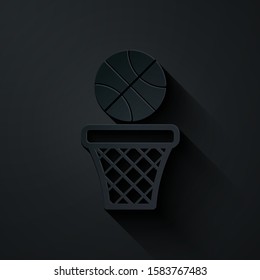 Paper cut Basketball ball and basket icon isolated on black background. Ball in basketball hoop. Paper art style. Vector Illustration