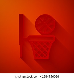 Paper cut Basketball ball and basket icon isolated on red background. Ball in basketball hoop. Paper art style. Vector Illustration