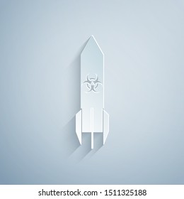 Paper cut Biohazard rocket icon isolated on grey background. Rocket bomb flies down. Paper art style. Vector Illustration