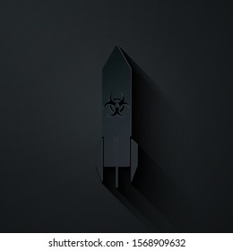 Paper cut Biohazard rocket icon isolated on black background. Rocket bomb flies down. Paper art style. Vector Illustration
