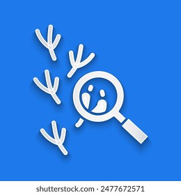 Paper cut Bird footprint under magnifying glass icon isolated on blue background. Animal foot. Paper art style. Vector